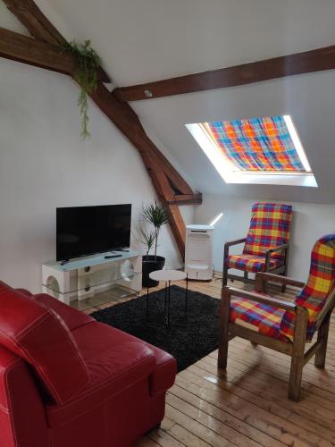 un salon avec un canapé et une télévision dans l'établissement Gite l'olivier, à Romilly-sur-Seine