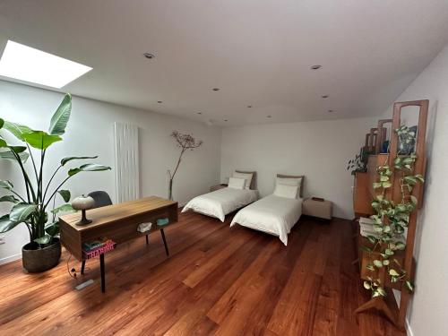 een woonkamer met 2 bedden en een houten vloer bij Studio Senang in Nijmegen