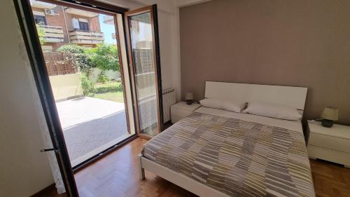 um quarto com uma cama e uma grande janela em La Casa di Trilly em Cerveteri