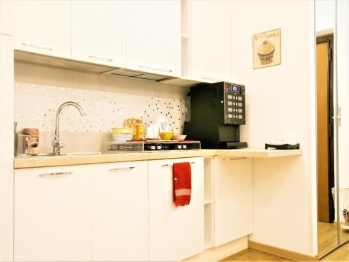 a white kitchen with a sink and a microwave at B&B Dea Tiburtina in Rome