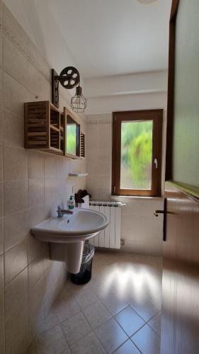 baño con lavabo blanco y ventana en La Casa di Trilly en Cerveteri