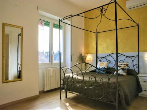 een slaapkamer met een bed met een metalen baldakijn bij Dea Tiburtina in Rome
