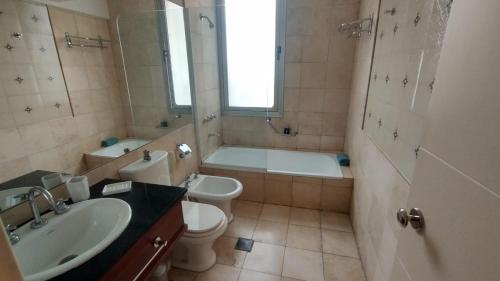 a bathroom with a tub and a toilet and a sink at Departamento Plaza Italia Executive in Mendoza