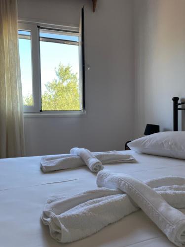 a room with three beds with white towels on them at Harry's House in Elafonisos
