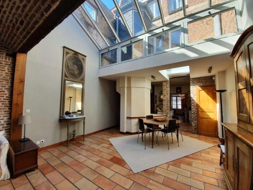 d'un salon avec une table, des chaises et une lucarne. dans l'établissement Coeur Vieux Lille , Bienvenue chez Nestyou, Lille, à Lille