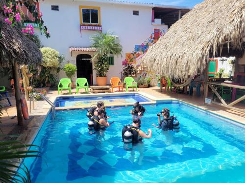 um grupo de pessoas na água em uma piscina em Divanga Hostel em Taganga