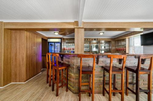 a kitchen with a bar with wooden stools at The Slipway in Colchester