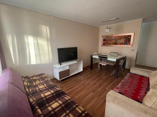 uma sala de estar com um sofá e uma mesa em Amplio Departamento - Edificio Tranquilo em Antofagasta
