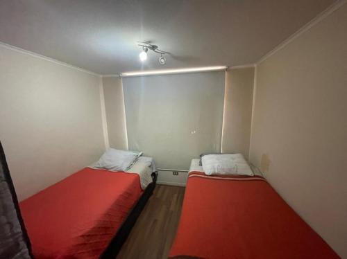 um pequeno quarto com duas camas em Amplio Departamento - Edificio Tranquilo em Antofagasta