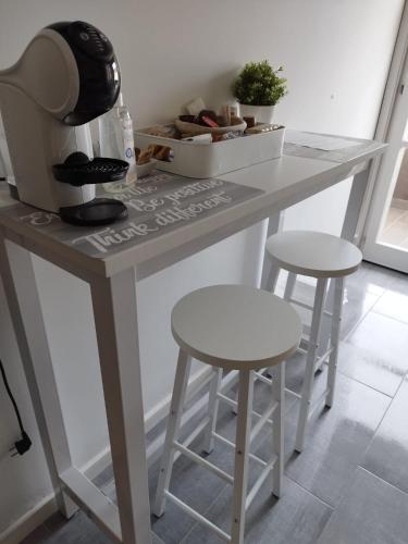 a kitchen counter with two stools and a table at b&b Casa Balai 72 a 100 mt dal mare in Porto Torres