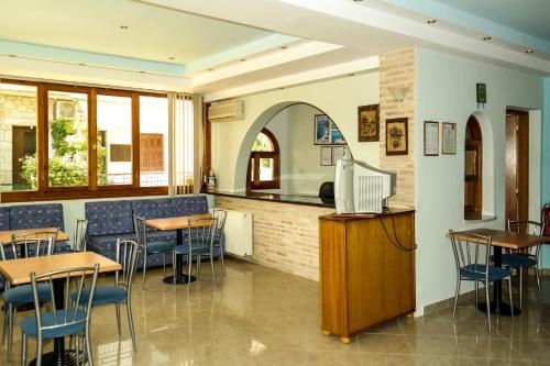 a restaurant with tables and chairs and a counter at Maistreli Hotel Apartments in Stoupa