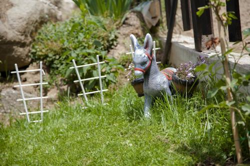 a statue of a rabbit standing in the grass at Къща за гости СИАНА in Dospat
