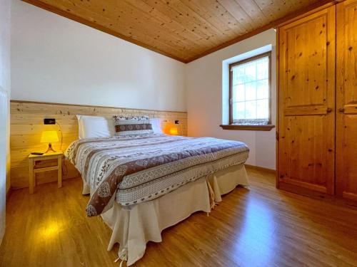 1 dormitorio con 1 cama en una habitación con ventana en Casa Cadore en Lozzo Cadore
