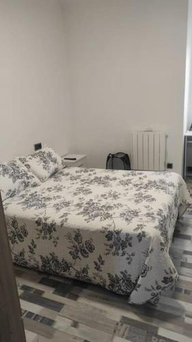 1 dormitorio con 1 cama con colcha de flores en Precioso piso en Ourense centro en Ourense