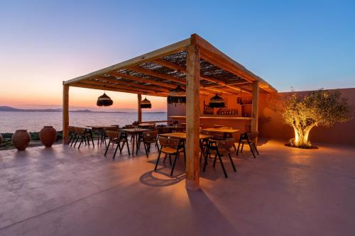 a restaurant with tables and chairs on the beach at Akre Hotel - Designed for Adults in Naxos Chora