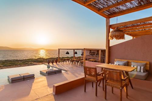 a patio with a table and chairs and the ocean at Akre Hotel - Designed for Adults in Naxos Chora