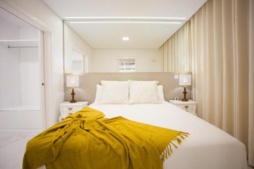 a bedroom with a bed with a yellow blanket on it at Pérola dos Anjos by LovelyStay in Funchal