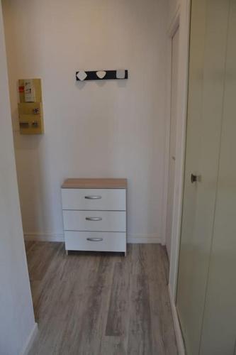Cette chambre blanche dispose d'une commode et d'un couloir. dans l'établissement Studio Les Sables d'Olonne, à Les Sables-dʼOlonne