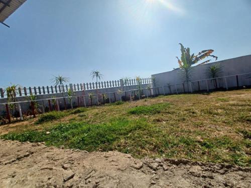 a fence in front of a field of grass at Odyssey Stays Nongrim, Cherrapunji in Cherrapunji
