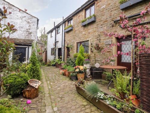 an outdoor garden with a table and some plants at 17th Century 2-bed/bath period cottage in Barrowford