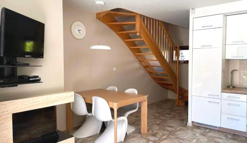 a dining room with a wooden table and a staircase at Apartament Pobierowo in Pobierowo