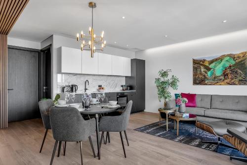 a dining room and living room with a table and a couch at ALVA Apartments in Reykjavík