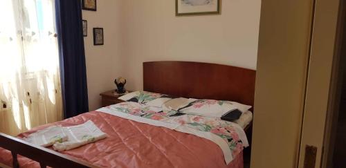 1 dormitorio con cama con sábanas rosas y ventana en LOURANTIANIKA HOUSE, en Citera