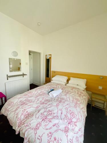 a bedroom with a bed with a pink and white comforter at The Danescourt in Blackpool
