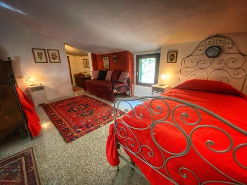 una camera con letto rosso e un soggiorno di Podere BARBI a Baschi