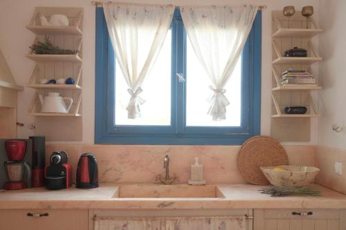 a kitchen with a sink and a window at Alia's sea view villa & studios in Apróvaton
