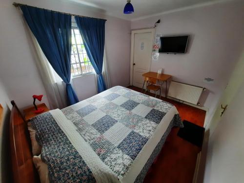 een slaapkamer met een bed met een quilt bij RESIDENCIAL METRO REPUBLICA in Santiago