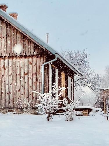 an old wooden barn with snow on it at Siedlisko pod Lipami in Lipinki