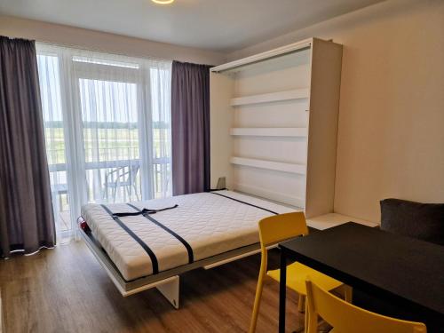 a bedroom with a bed and a desk and a window at Ku kū in Šventoji