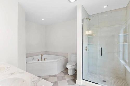 bagno bianco con vasca e servizi igienici di Stylist East Hampton Home a East Hampton