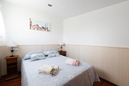 ein Schlafzimmer mit einem Bett mit Handtüchern darauf in der Unterkunft Acogedora casa p/3 c/parking a 5 min de la playa in Nigrán