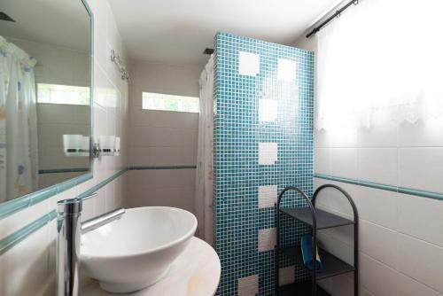 ein Badezimmer mit einem weißen Waschbecken und einer Dusche in der Unterkunft Acogedora casa p/3 c/parking a 5 min de la playa in Nigrán