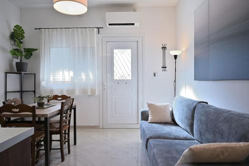 sala de estar con sofá azul y mesa en Seabreeze apartment in Palaio Faliro/ Netflix, en Atenas