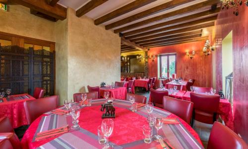 uma sala de jantar com mesas vermelhas e cadeiras vermelhas em Appartement d'une chambre avec jardin clos et wifi a Fauverney em Fauverney