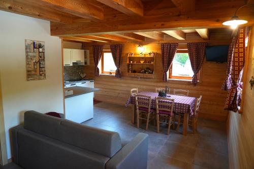 Raveo的住宿－Chalet Navauce，厨房以及带桌子和沙发的用餐室。