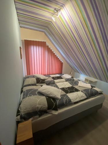 a bedroom with a bed with a rainbow ceiling at Ada Vendégház in Öskü