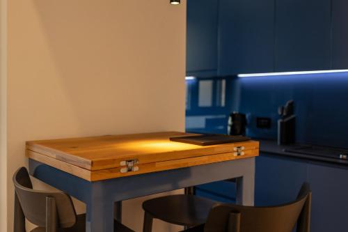 a blue kitchen with a wooden table and chairs at Rosetti One in Constanţa