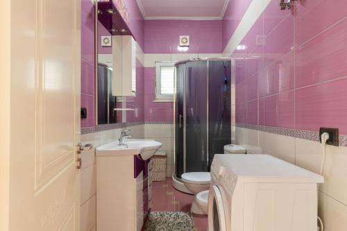 ein lila Badezimmer mit einem WC und einem Waschbecken in der Unterkunft The Lake Houses in Shirokë