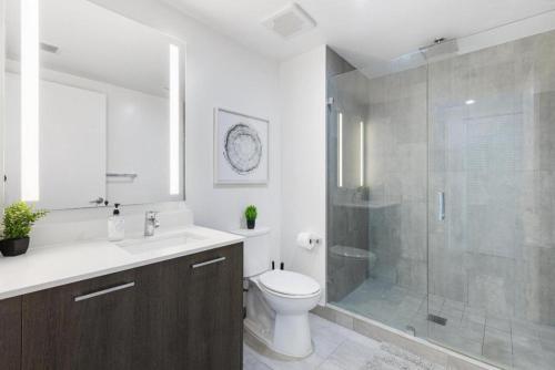 a bathroom with a shower and a toilet and a sink at Corner condo w/ Unrivaled views in Miami