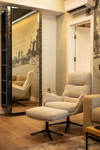 a living room with two chairs and a mirror at Rosetti One in Constanţa