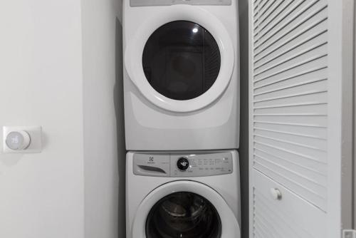 a washing machine and a dryer next to a wall at Corner condo w/ Unrivaled views in Miami