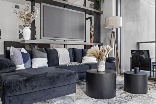 a living room with a blue couch and a tv at Corner condo w/ Unrivaled views in Miami