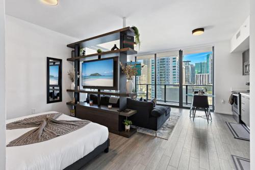 a bedroom with a large bed and a living room at Corner condo w/ Unrivaled views in Miami