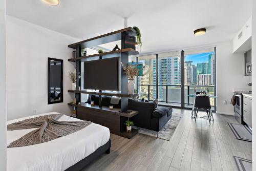 a bedroom with a large bed and a living room at Corner condo w/ Unrivaled views in Miami