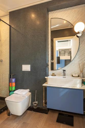 a bathroom with a sink and a toilet and a mirror at Rosetti One in Constanţa