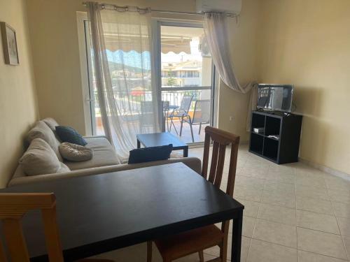 a living room with a couch and a table with chairs at Sunset Apartment in Vonitsa